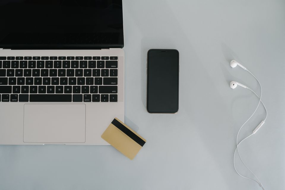 机に置かれたノートPC、スマートフォン、クレジットカード