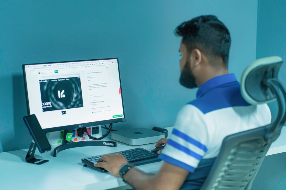 デスクトップPCの前に座り、キーボードとマウスを操作する利用者